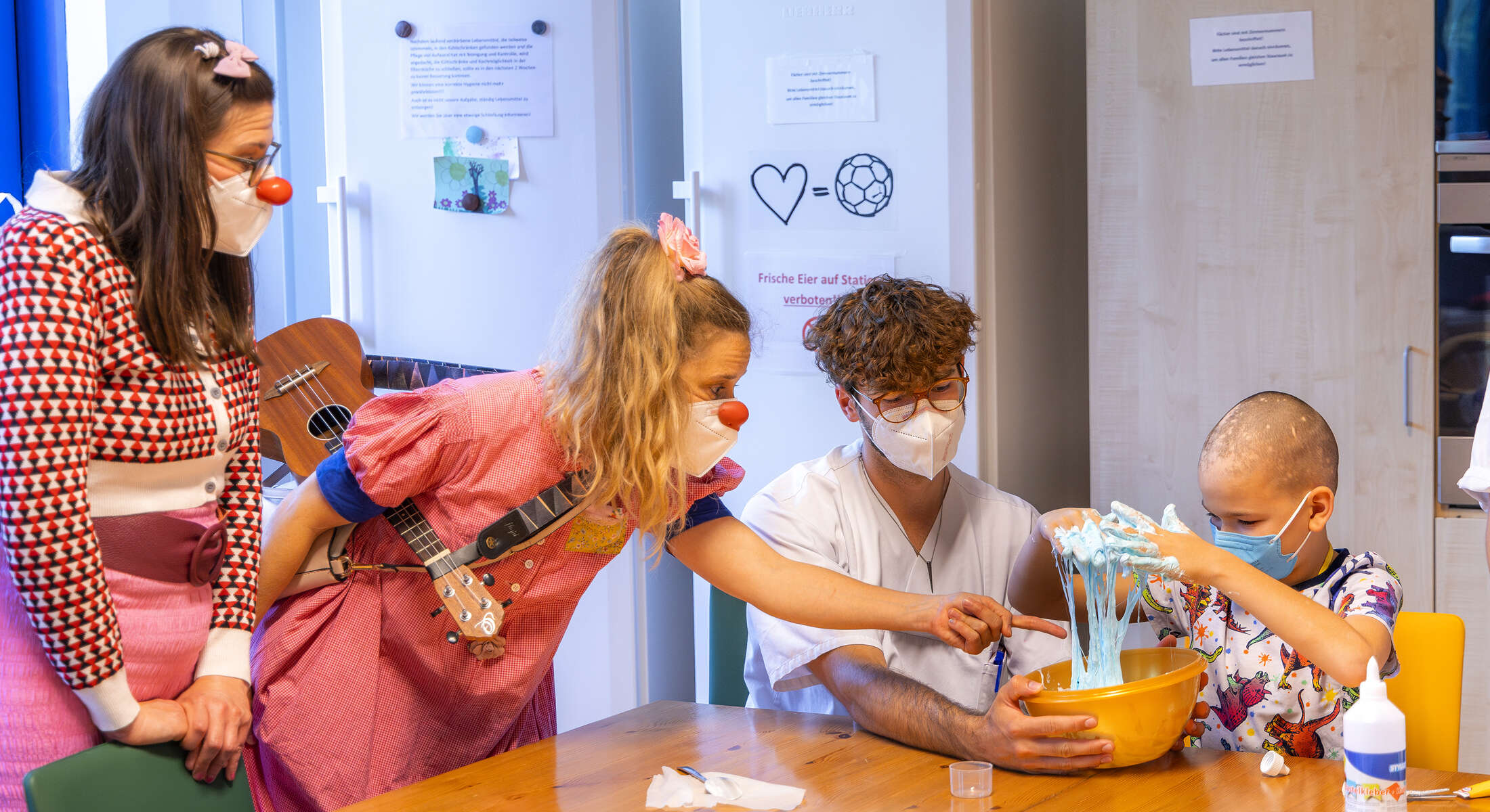 ROTE NASEN Clowninnen auf der Kinderkrebsstation mit einem kleinen Patienten.