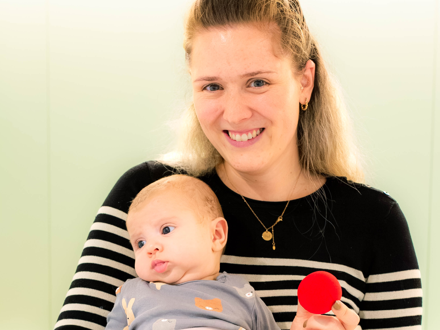 Eine Mama mit ihrem Baby im Arm im Spital.