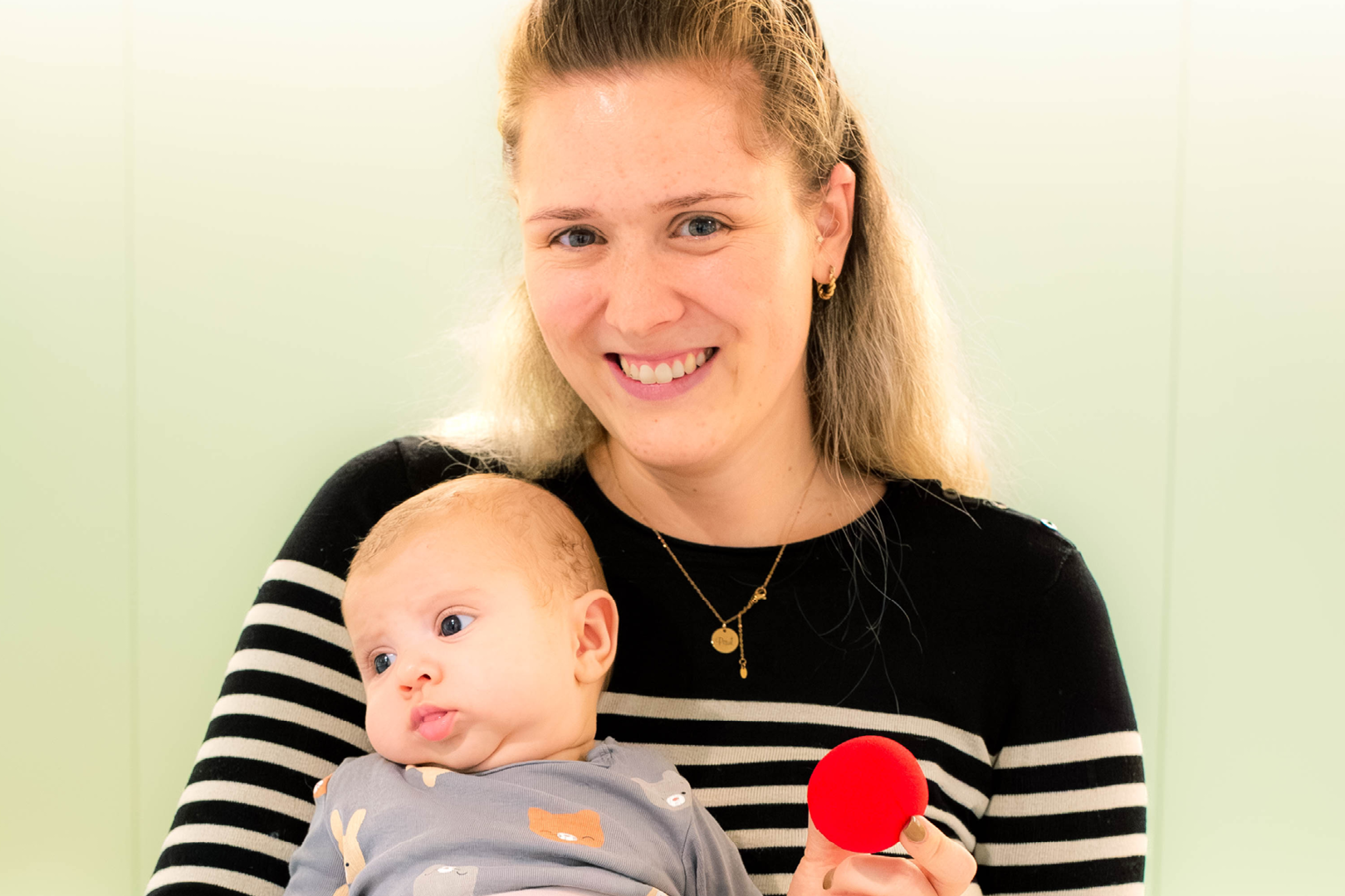 Eine Mama mit ihrem Baby im Arm im Spital.