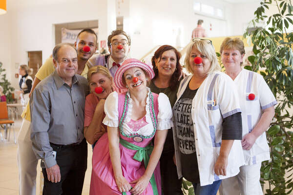 Pflegepersonal aus dem Pflegeheim Neudörfl posieren gemeinsam mit zwei ROTE NASEN Clowns