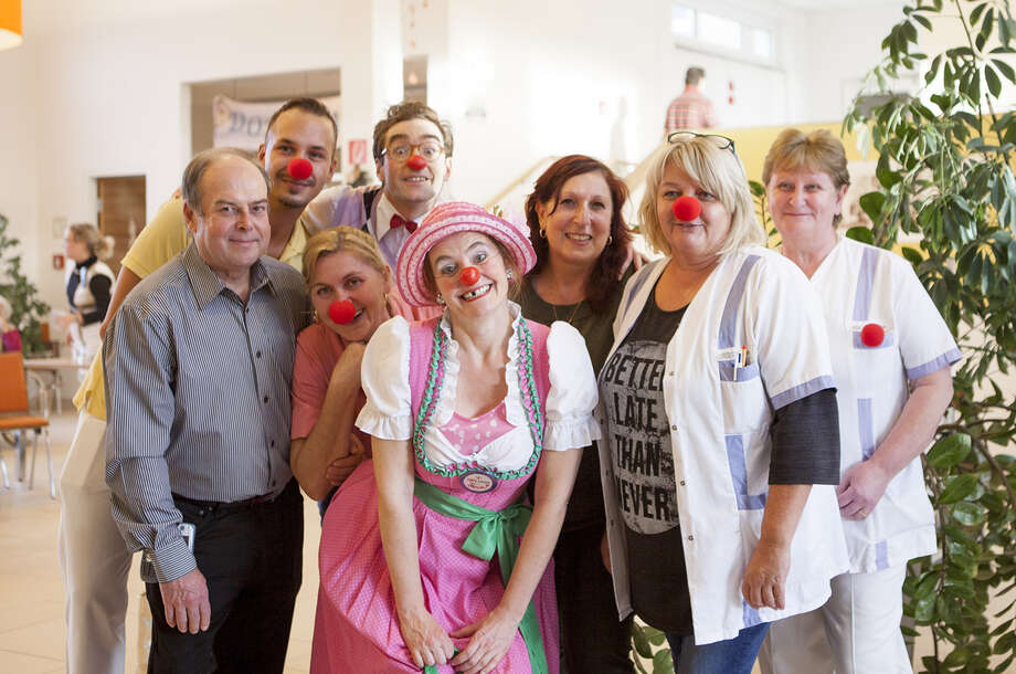 Pflegepersonal aus dem Pflegeheim Neudörfl posieren gemeinsam mit zwei ROTE NASEN Clowns