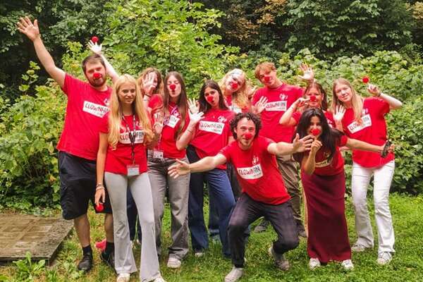 Eine Gruppe gutgelaunter Straßenwerber:innen in einem Park.