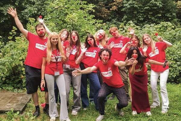 Eine Gruppe gutgelaunter Straßenwerber:innen in einem Park.