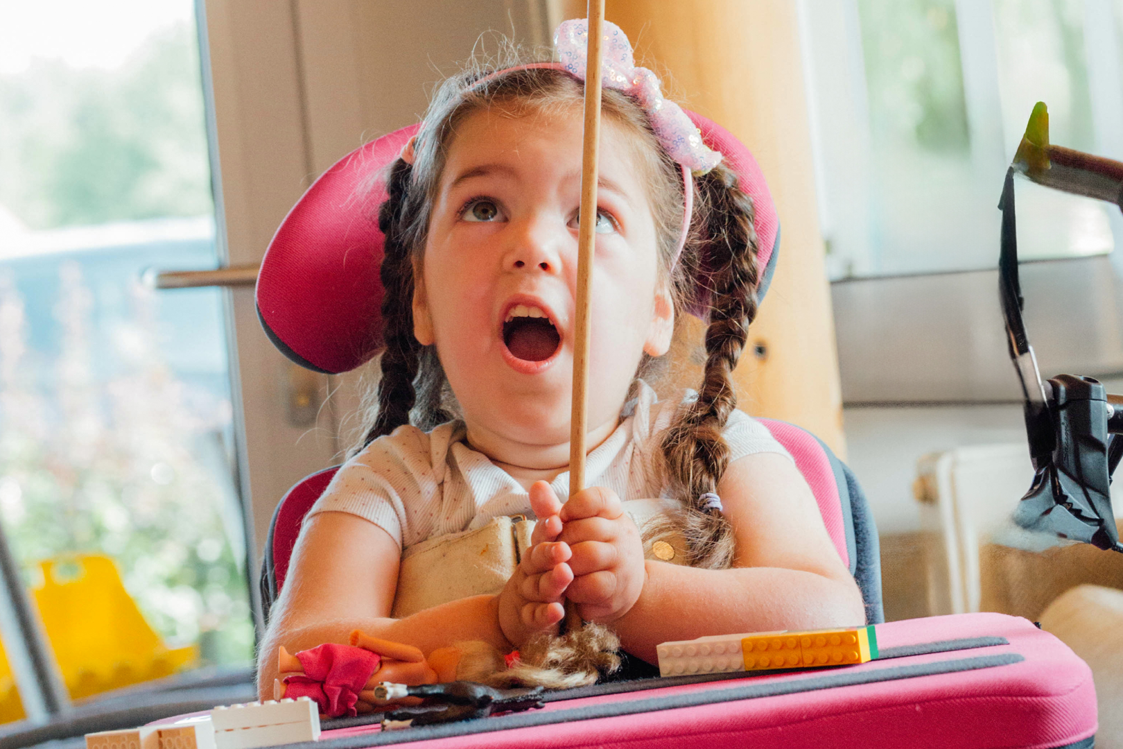 Ein Mädchen im Rollstuhl balanciert einen Teller auf einem Stäbchen.