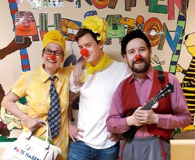Zwei Clowns und Ö3-Moderator Philipp Hansa posieren vor einer bunten Wand im SMZ-Ost