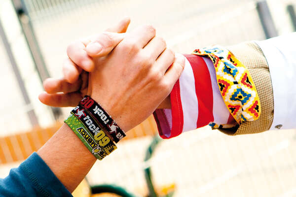 die Hand einer Schülerin und die Hand eines Clowns die einander halten