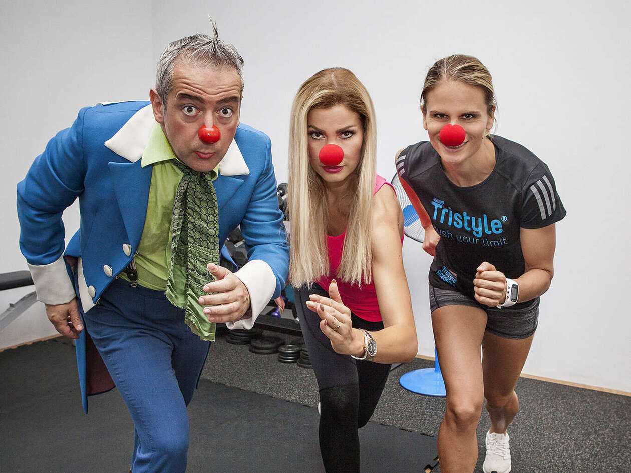 Ein ROTE NASEN Clown und zwei Frauen mit roter Schaumstoffnase posieren in die Kamera