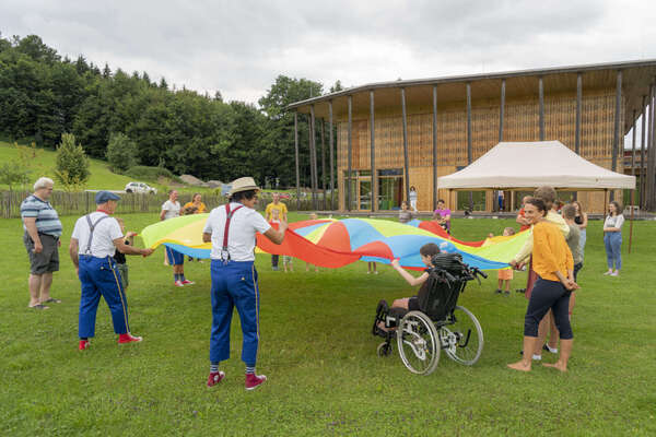 ROTE NASEN Künstler*innen mit kleinen Langzeitpatient*innen im Spiel mit einem großen Tuch.