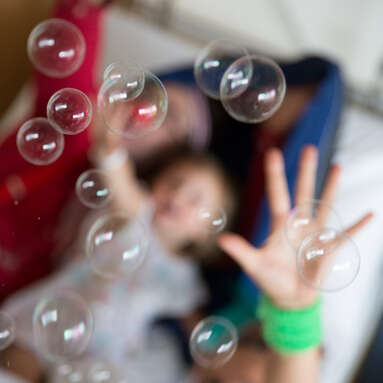 Clownin Dagma und Markus greifen nach den Seifenblasen