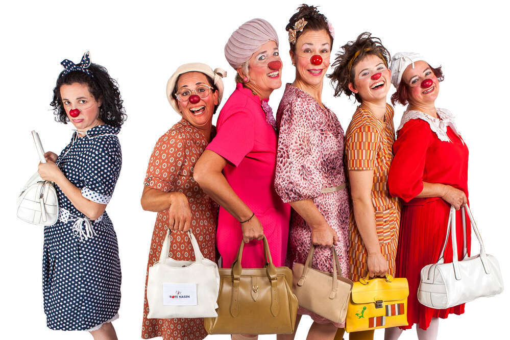 5 Clowninnen stehen hintereinander in einer Reihe und präsentieren stolz ihre Handtaschen