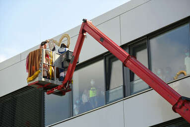 Auch während der Corona-Pandemie und der Lockdowns besuchen die ROTE NASEN Patientinnen und Patienten, hier auf einer Arbeitsbühne.