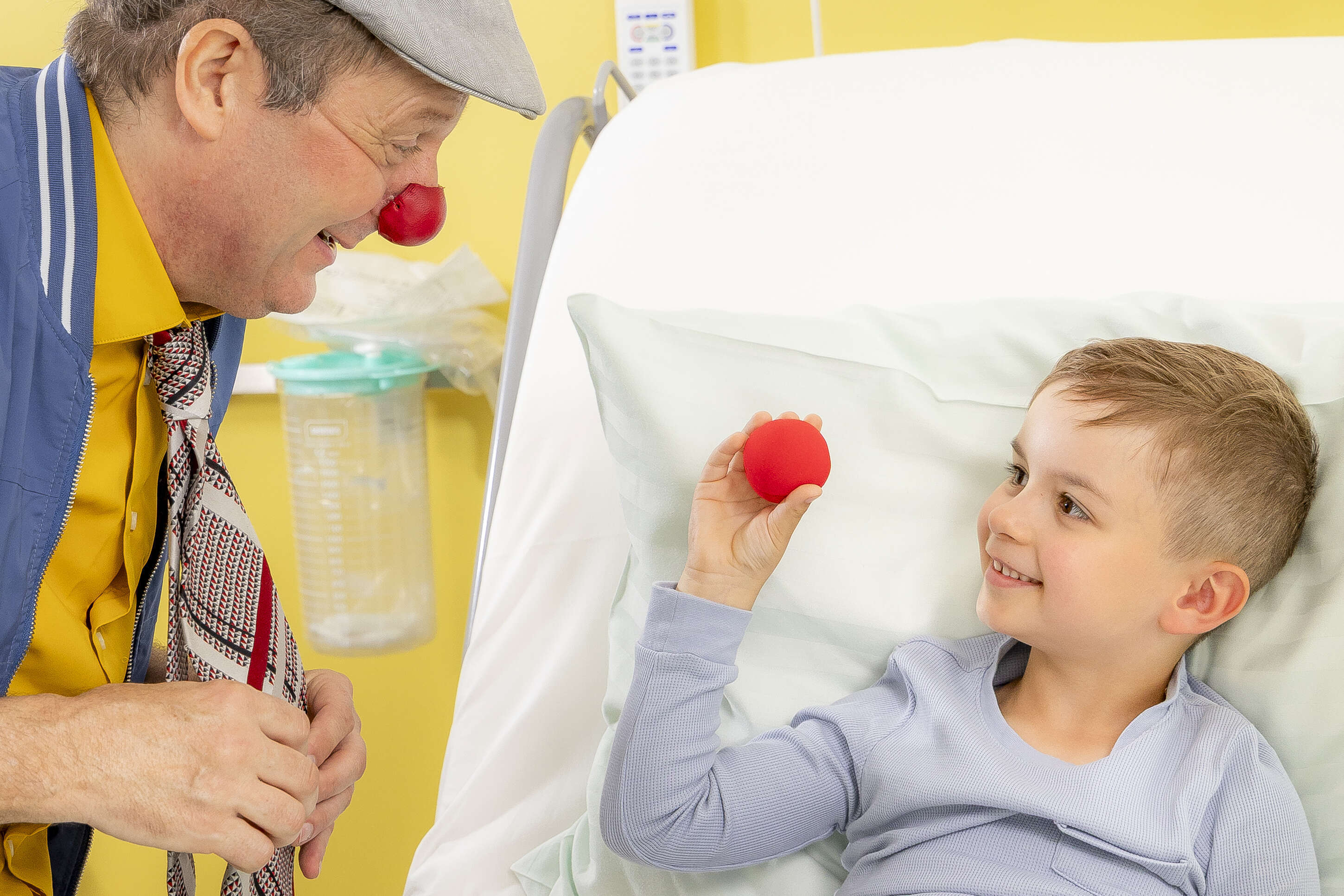 ROTE NASEN-Clown Guido zu Besuch bei einem Jungen an dessen Krankenbett.