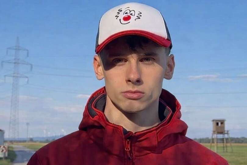 Ein junger Mann mit ROTE NASEN Kappe und roter Jacke.