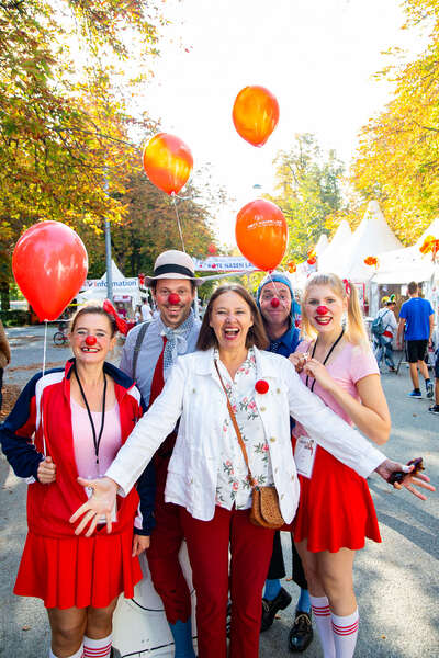 Vier ROTE NASEN Clowns und Geschäftsführerin Edith Heller posieren lachen für ein Foto