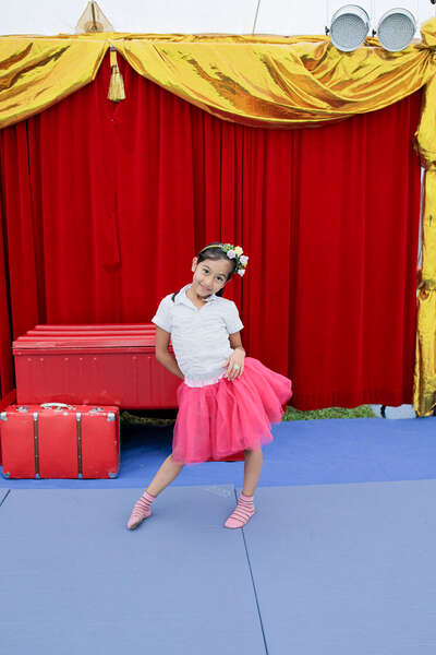 Ein Mädchen posiert im Zirkuszelt und lacht