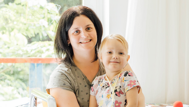 Eine Mutter hält ihre kleine Tochter in den Armen.