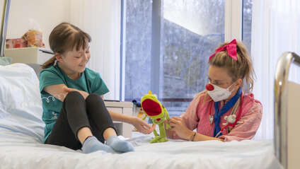 Ein Kind auf der Kinderonkologie im LKH Graz mit Clownin Paula.
