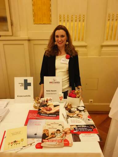 ROTE NASEN-Mitarbeiterin Mag. Selina Brandauer vor einem Messestand.