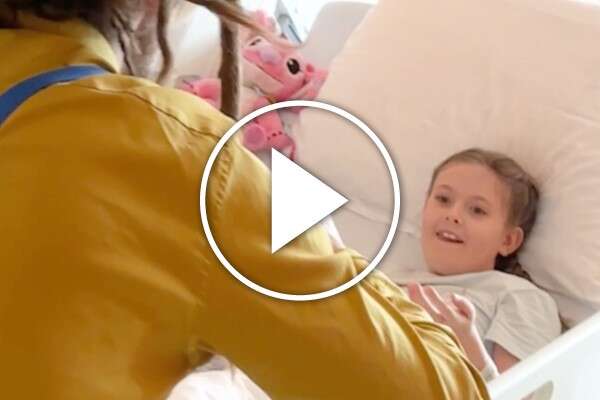 Clown Chico zaubert mit einem Mädchen im Spital Seifenblasen.