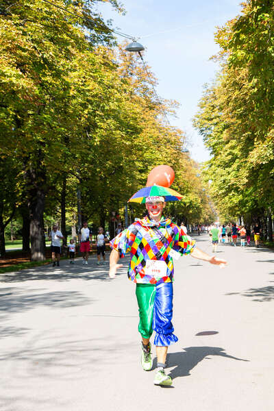 Läufer im Clownskostüm lacht in die Kamera
