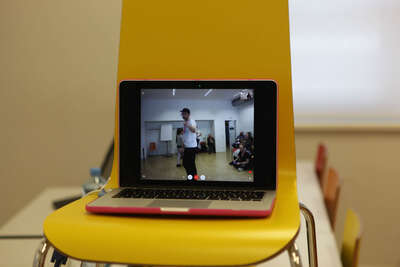 geöffneter Laptop steht auf einem gelben Sessel