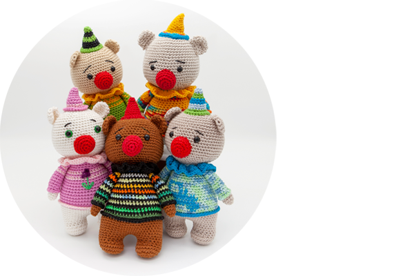 Fünf verschiedene bunte Häkelbärchen mit roter Nase.