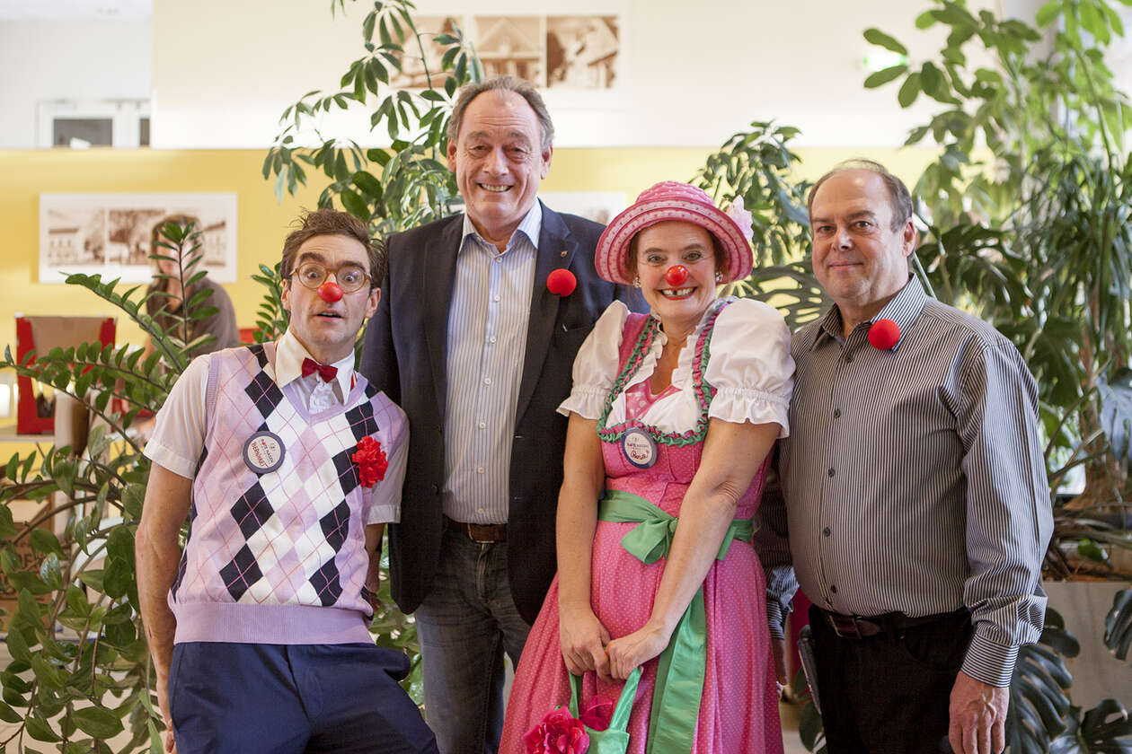 Bürgermeister von Neudörfl und Pflegedienstleiter des Pflegeheims Neudörfl posieren mit zwei Clowns