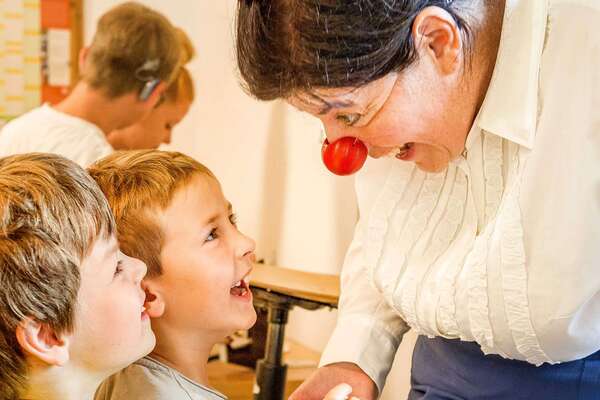 ROTE NASEN-Clownin Aloisia unterhält sich mit zwei Jungen.