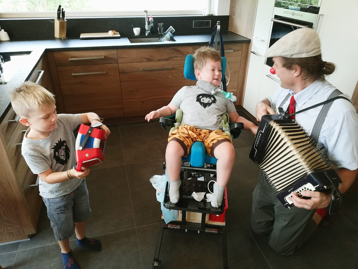 Linus und Guido halten eine Ziehharmonika in der Hand und spielen Marius ein Lied vor.