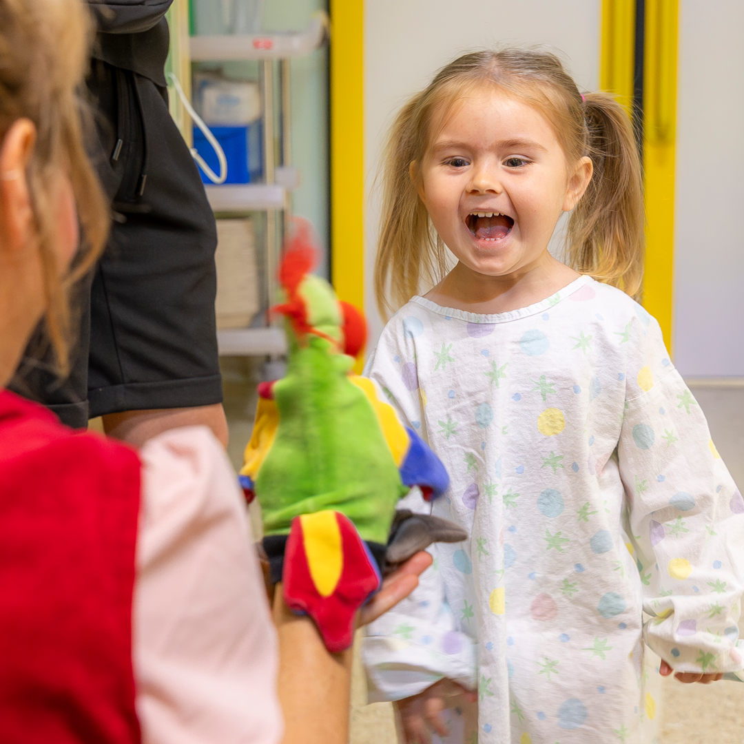 Clownin Lilo im Spiel mit einer Handpuppe und einem Mädchen, das lacht.