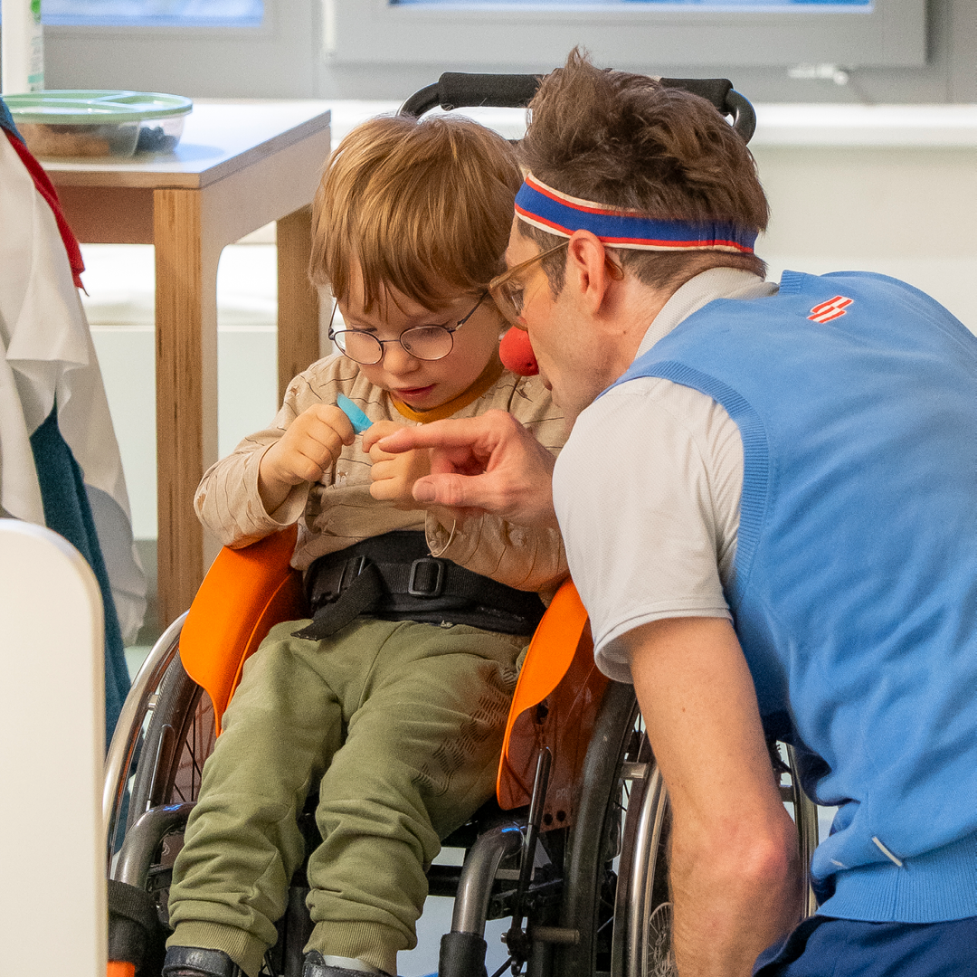 Junge in Rollstuhl mit Clown