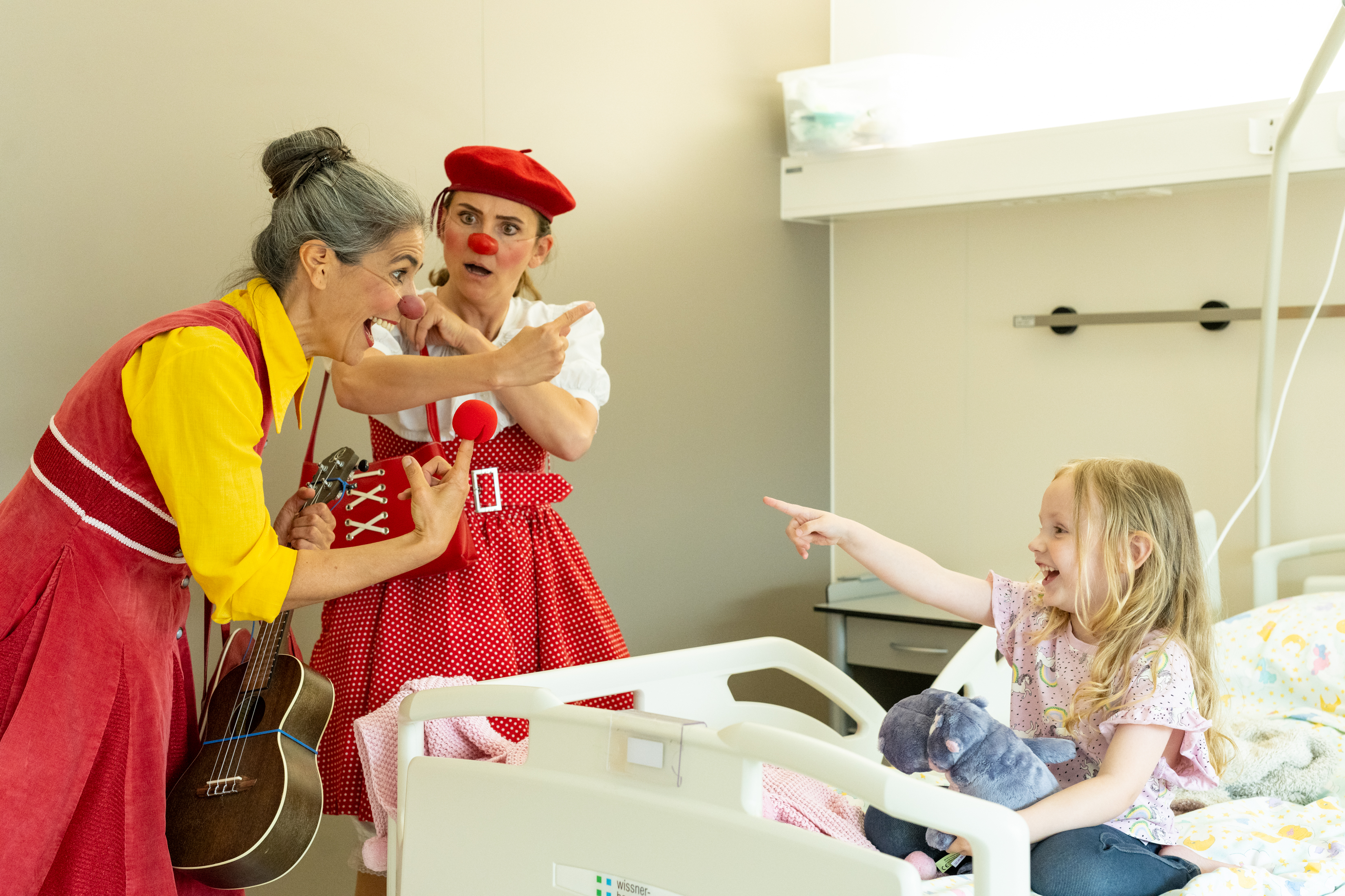 ROTE NASEN-Clowninnen Rita und Luise besuchen ein kleines Mädchen in deren Krankenzimmer.