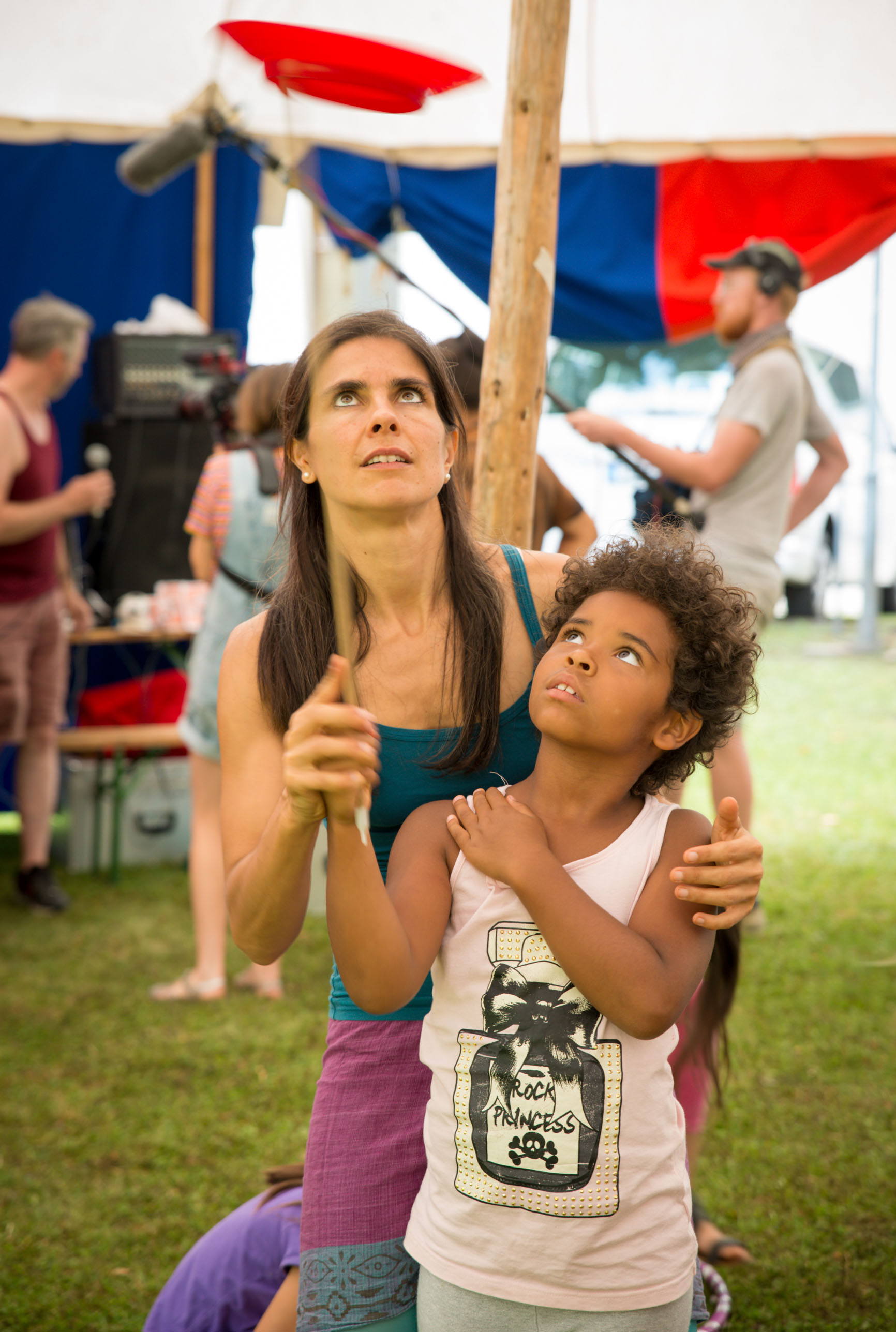 Frau hilft kleinem jungen beim Tellerkreisen