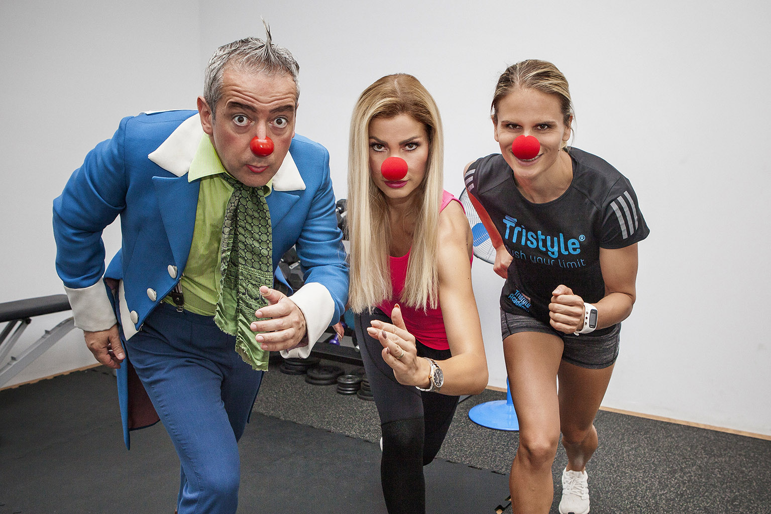 Ein ROTE NASEN Clown und zwei Frauen mit roter Schaumstoffnase posieren in die Kamera