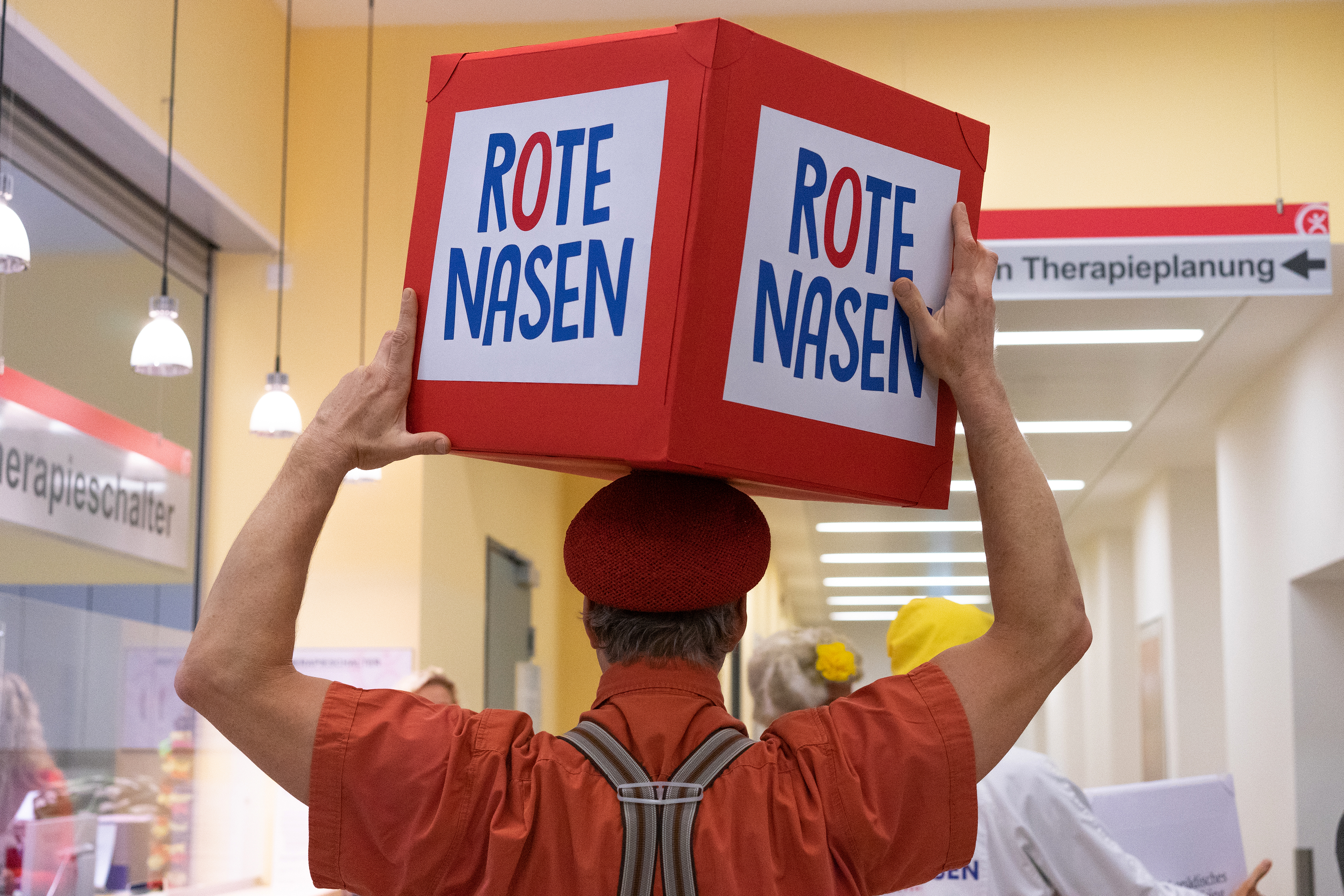 ROTE NASEN-Clown Norbert trägt einen roten Würfel mit der Aufschrift "ROTE NASEN".