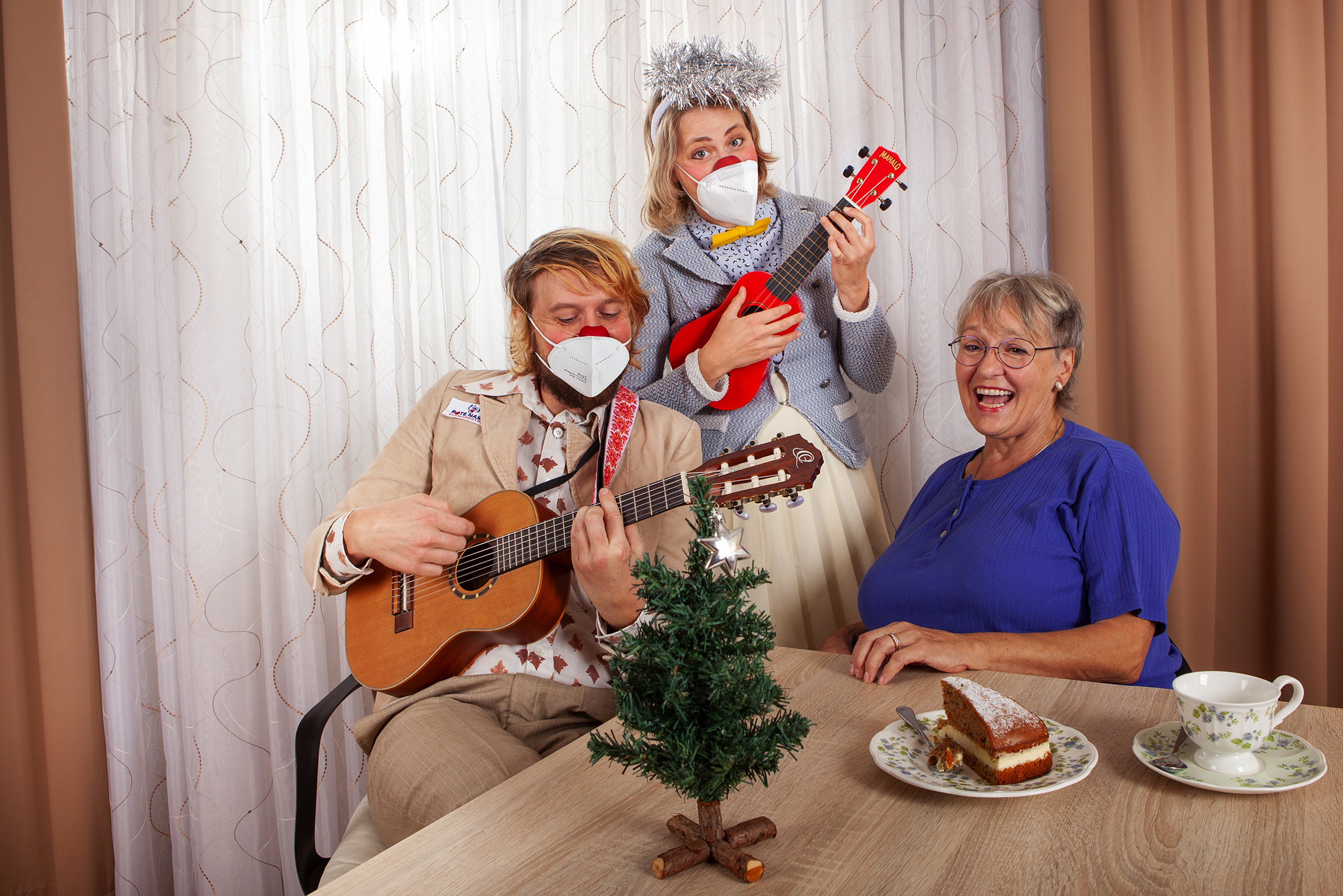 ROTE NASEN-Clowns Lasse und Trixie spielen mit ihren Gitarren ein Ständchen für eine Krankenhausangestellte.