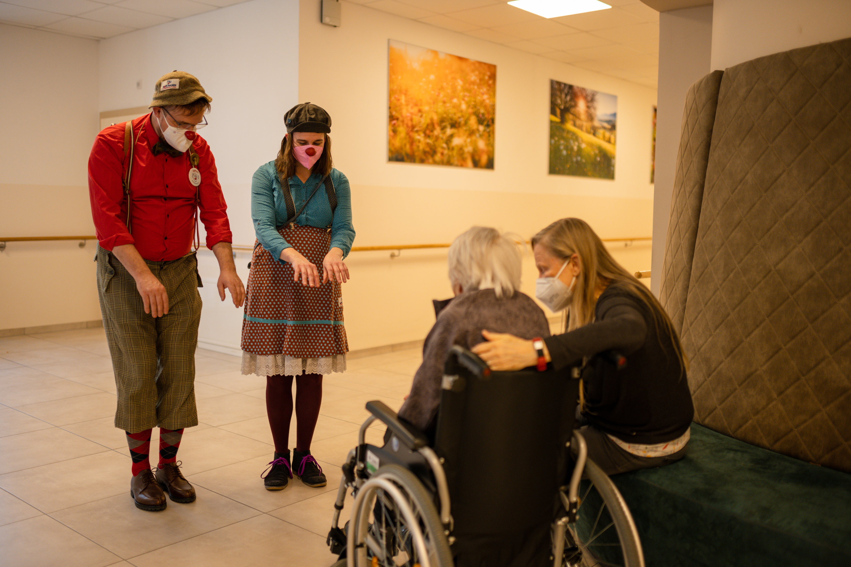 ROTE NASEN-Clowns Raimund und Marie bei einer Interaktion mit einer älteren Dame, die an Demenz erkrankt ist.