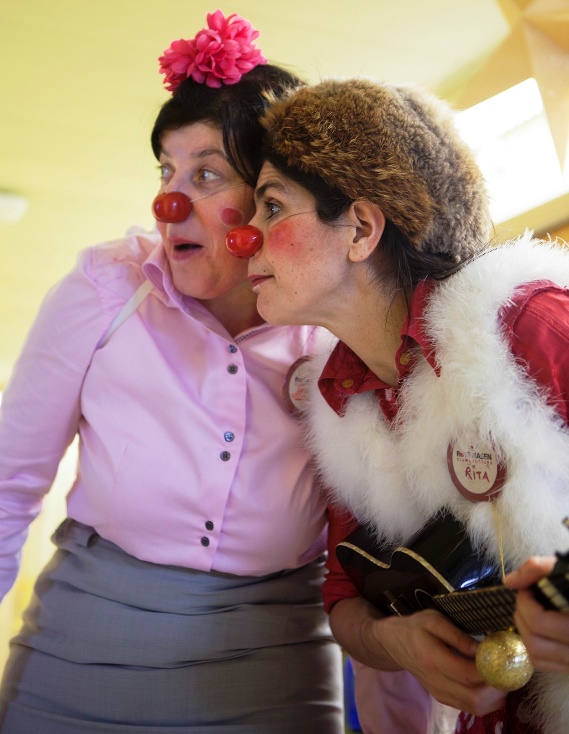 Zwei Clowninnen blicken suchend auf die Seite