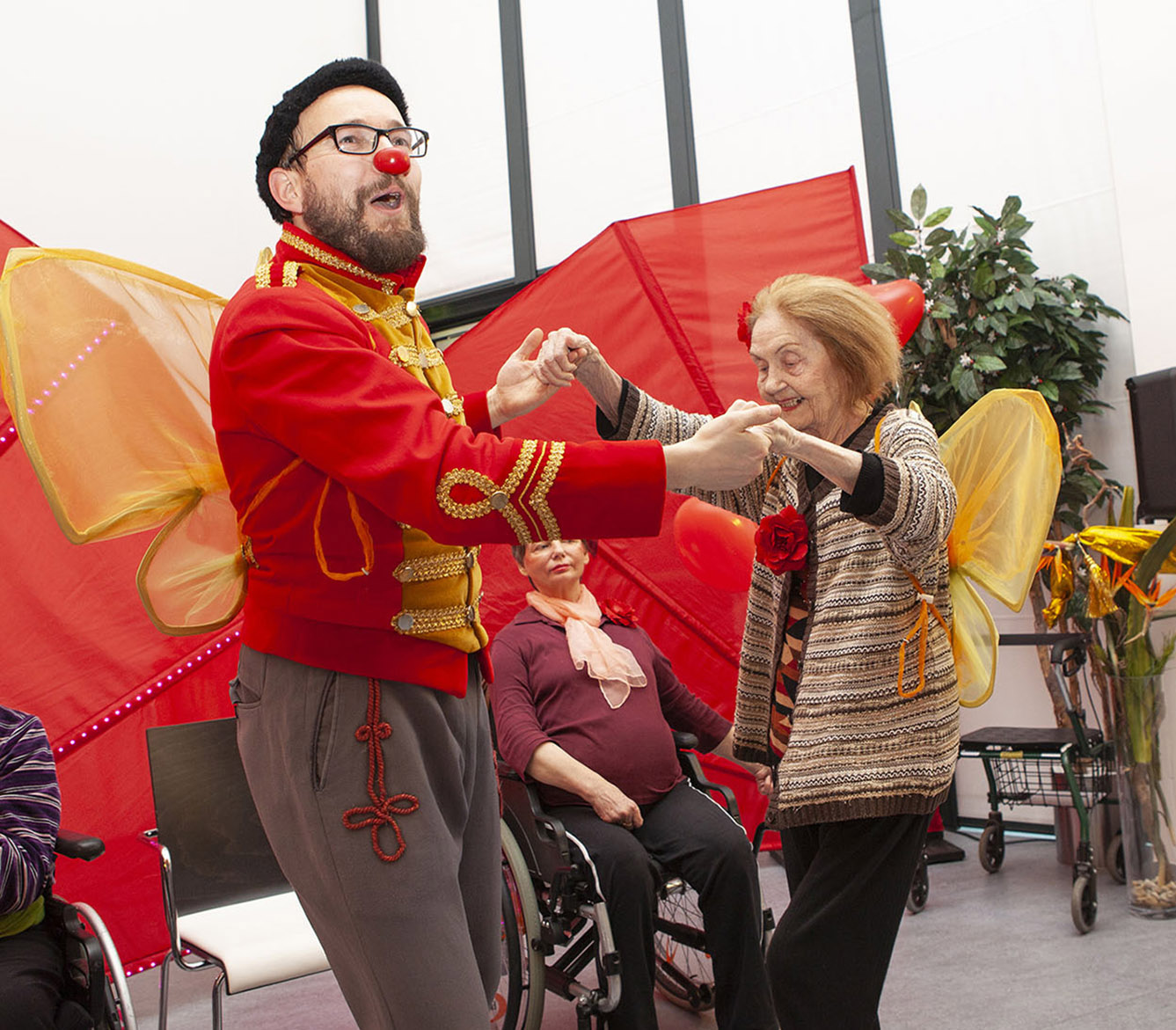 Rote Nasen Clown tanzt mit Bewohnerin